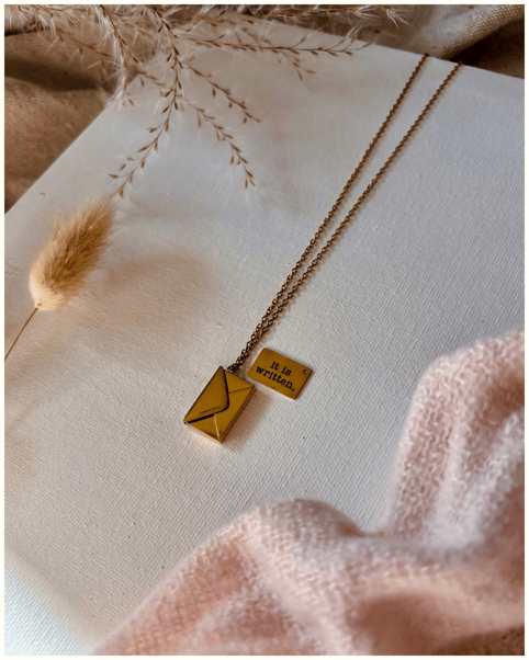 a necklace a small gold envelope. It is written necklace.