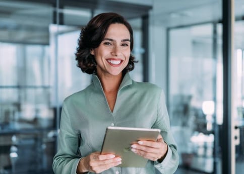 a smiling woman holding a tablet computer and smiling