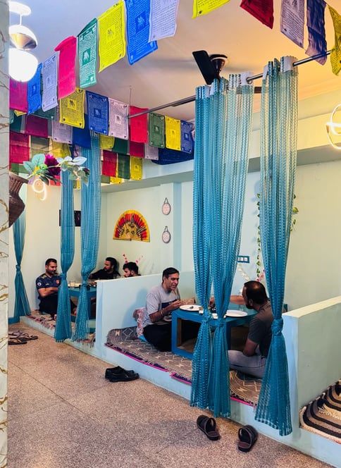 a group of people sitting at tables with colorful flags