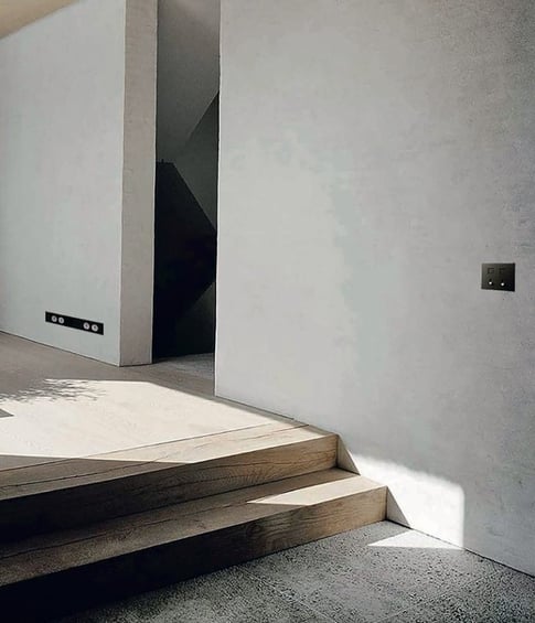 Espacio de diseño con interruptores negros integrados en pared clara y arte contemporáneo