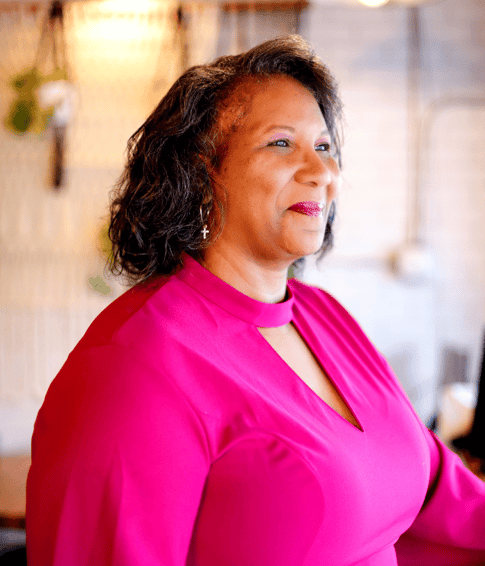 Pastor Dezi Epps Berry in pink dress and smiling brightly