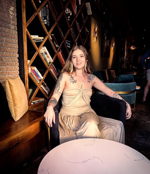 a woman sitting in a chair with a tattoo on her arm