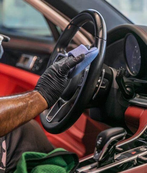 Limpieza interiorLimpieza interior de automóvil con pañ de automóvil con paño azul sobre el volante.