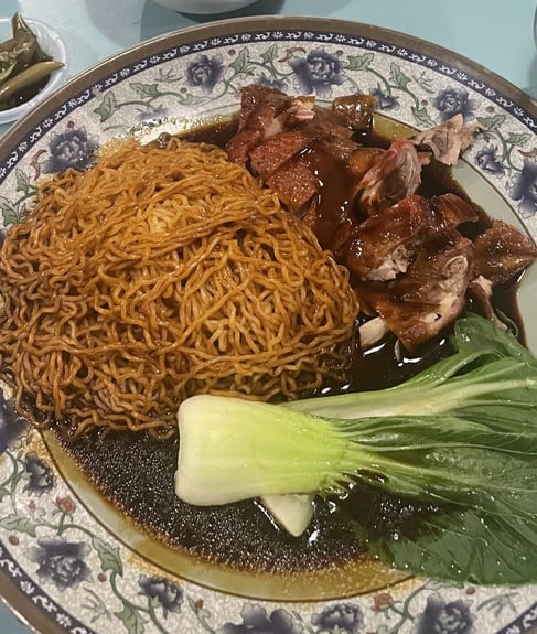 Cha sieuw or char siu mee/noodles in a dark sauce with bokchoy and wonton soup on the side 