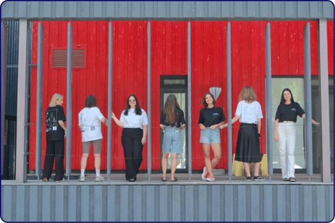 A group of people from Linkedist standing in front of a red wall