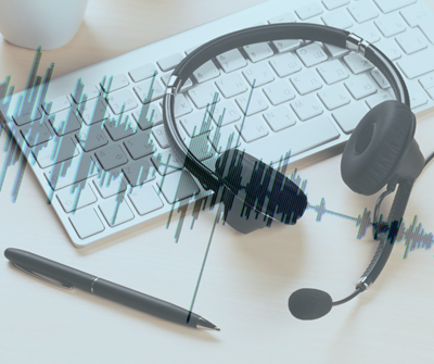 A keyboard, a pen, and headphones representing audio and video translations