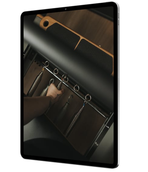 iPad with hand changing Pilates Reformer springs