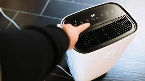 a person holding a small air conditioner