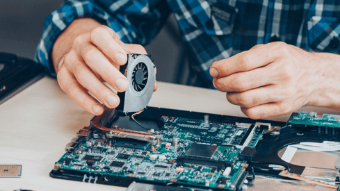 a man is repairing a computer motherboard