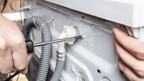 a person is fixing a dishwasher in a kitchen
