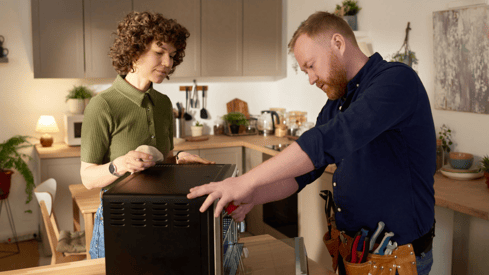 a man and woman standing in a kitchen