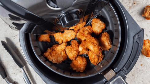 a fryer with chicken nuggling in it