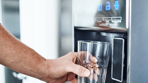 a person holding a glass of water in a glass