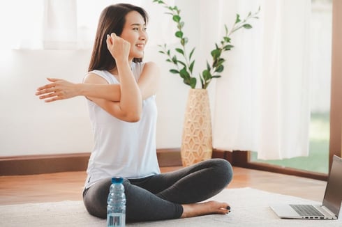 woman sitting on floor stretching 