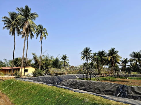 green lush lawn with canal for boating in resort near surat