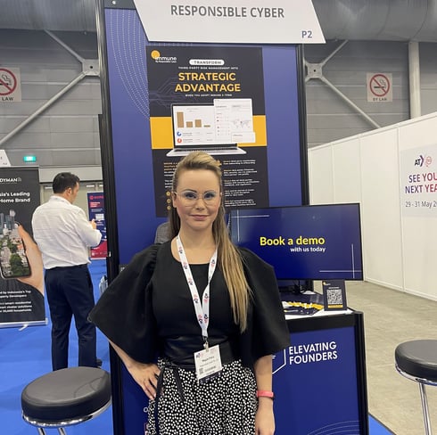 a woman standing in front of a display of Responsible Cyber booth