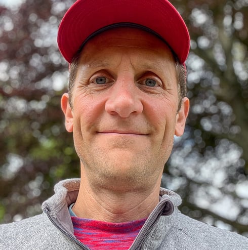 Headshot of Marcus wearing a red hat
