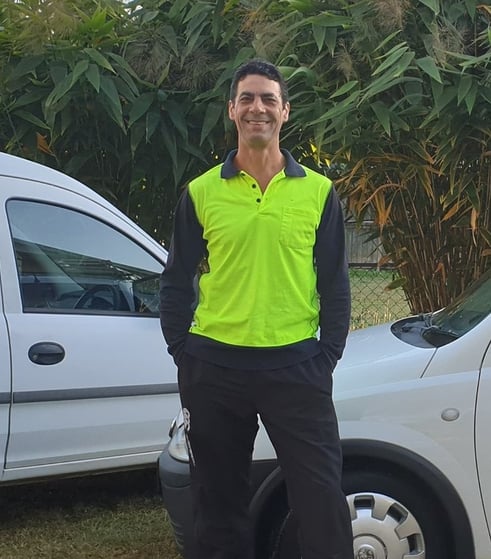 danny weller aqua clear window cleaning owner operator smiling in an outdoor setting, standing in front of work vehicles