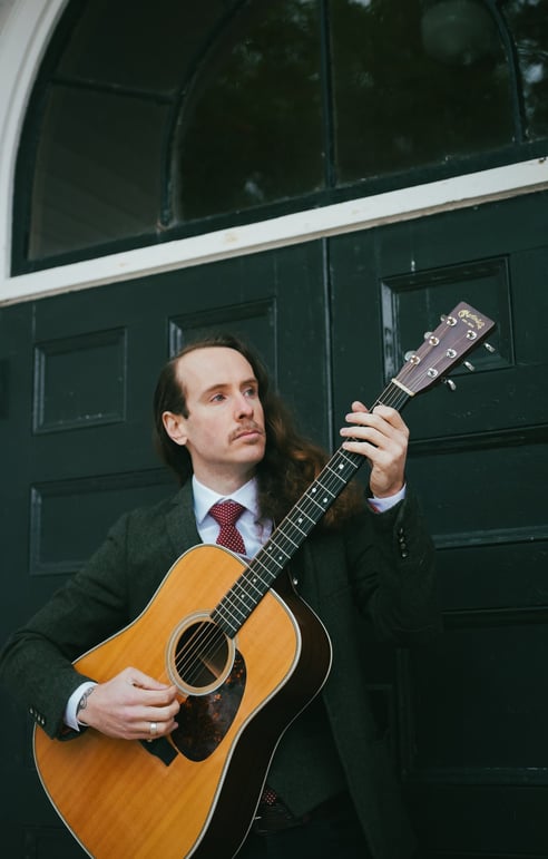 a man in a suit and tie playing guitar
