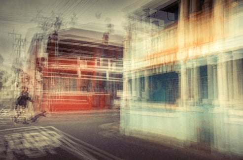 Abstract photograph of a man crossing a colourful Woodstock street, Cape Town, layered exposures blending bright colours