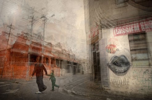 Abstract layered street scene in Cape Town showing a woman and child walking past red buildings and graffiti lips mural.