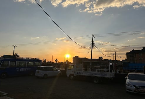 a bus stop at sunset with the sun setting