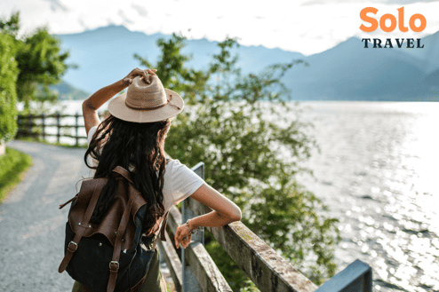 a woman in a hat and a backpacker on a path