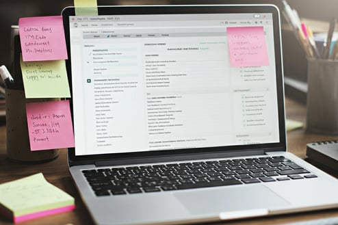 a laptop computer sitting on a desk with sticky notes and sticky notes