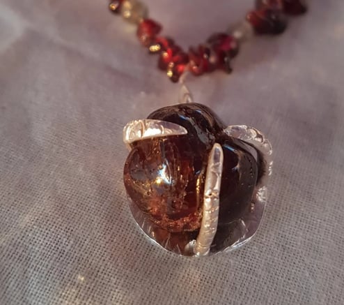 Collar artesanal con cuentas de granate y colgante de piedra marrón en engaste de plata. Joyería 