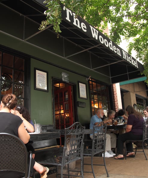 a group of people sitting at tables outside a restaurant