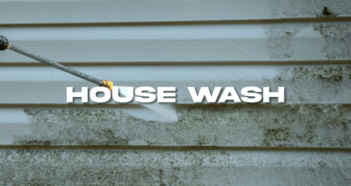 a person using a hose to clean a house