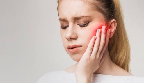 TMJ pain causing difficulty in chewing and jaw stiffness.