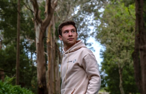 a man in a hoodie in a forest