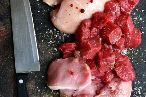 a knife and meat on a cutting board