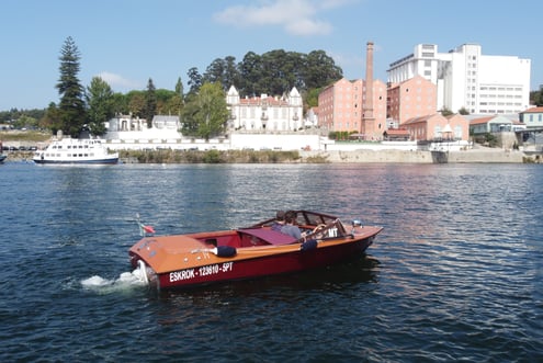 Couple enjoying private vintage wooden boat tour on the Douro River in Porto, Portugal