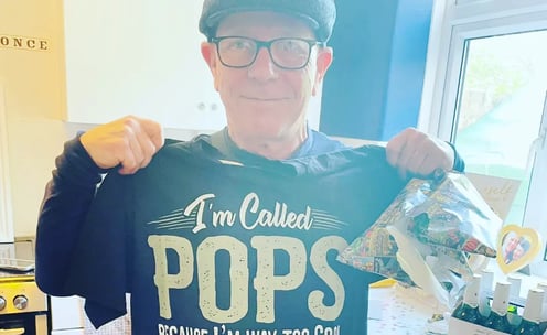 Rob Hamilton holding up a T shirt to say he is a pops