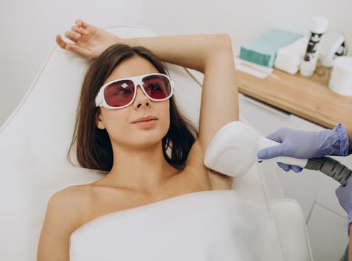 a woman in eye protection getting laser hair removal treatment her hair done