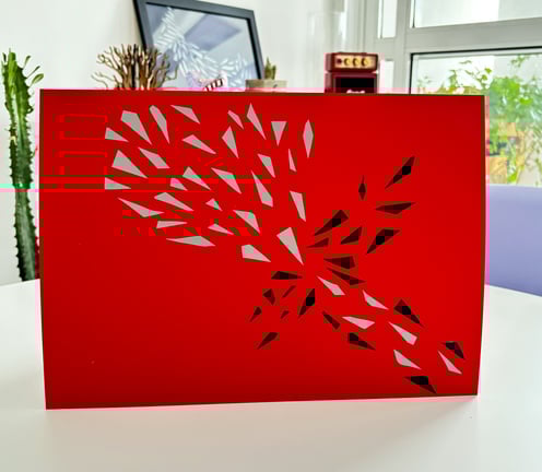 arte em fita isolante prata e preta sobre papel vermelho.