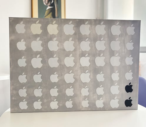 foto da arte contemporânea composta de uma tela de 70x50 cm pintada em cinza claro coberta por 48 adesivos da apple.
