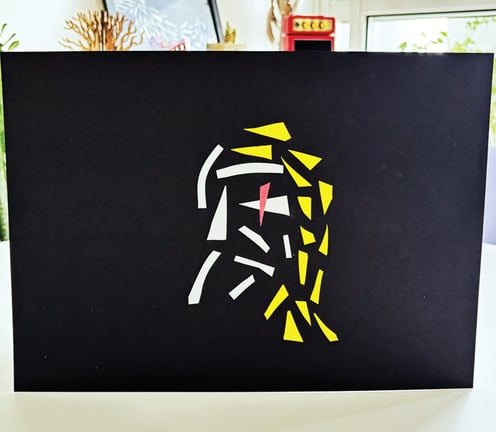 arte contemporânea feita de fitas isolante e washi, formando um homem de cabelo amarelo e olho vermelho sobre fundo preto.