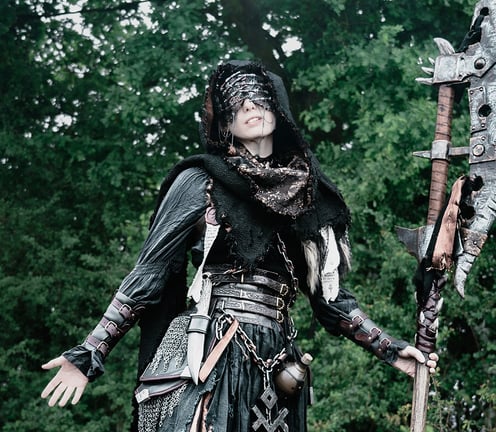 Capuche unique aux teintes de marron rouille et cuivre sur une femme en tenue fantasy