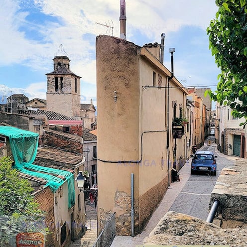 And older architecture with a narrow odd shaped house and a layered medieval street