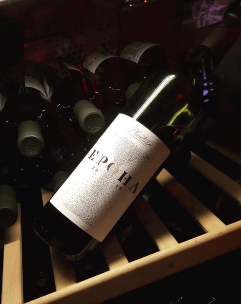 a bottle of wine is sitting on a wooden crate