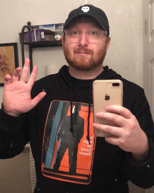 a man in a black hoodie and a phone