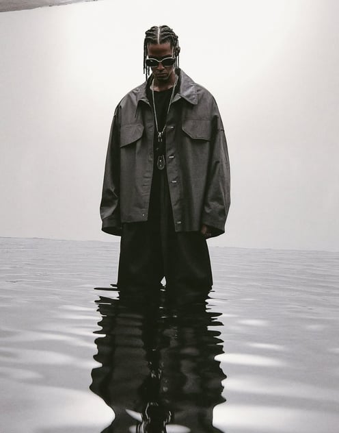 a man standing in the water with a hat and sunglasses