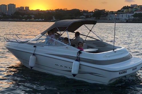 Family enjoying private boat tour at sunset on the Douro River in Porto, Portugal