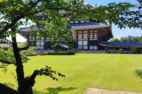 a large building with a large grassy field