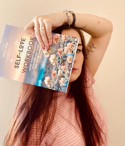 woman holding self love workbook