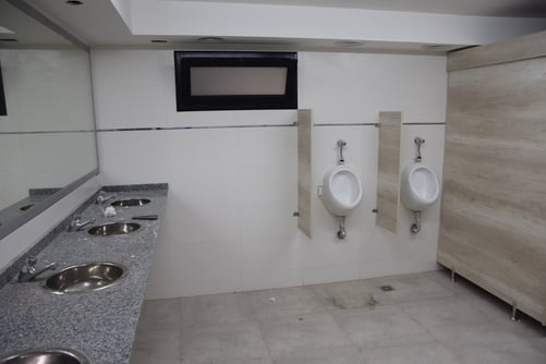 piletas y mingitorio en baño de fábrica