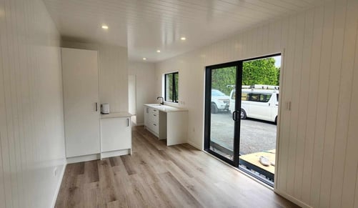 View of kitchen cupboard and sliding door of tiny home